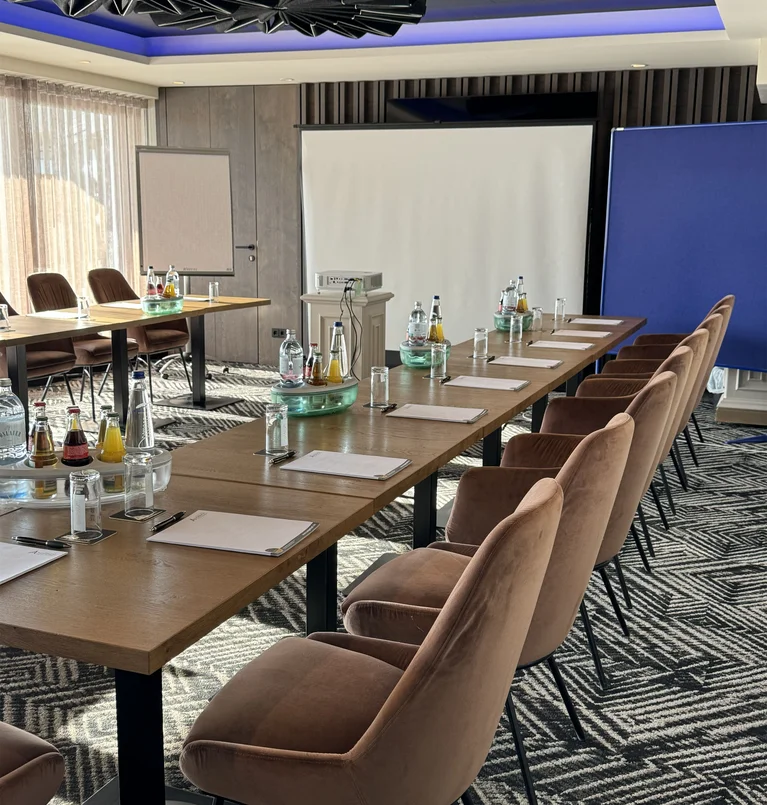 Die Adresse für Wellness in Bayern: Ihr Hotel in St. Englmar Moderner Konferenzraum mit Tischen, Stühlen, Flipchart und Projektionsleinwand