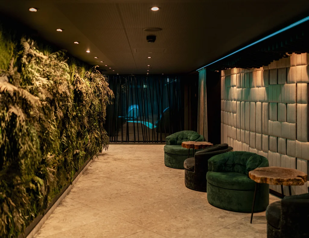 Die Adresse für Wellness in Bayern: Ihr Hotel in St. Englmar Moderner Flur mit grünem Pflanzenwand und grünen Sesseln